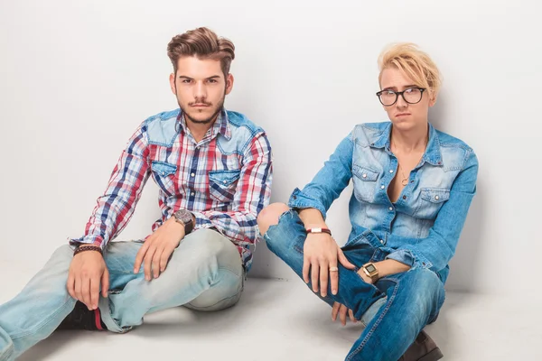 Two pensive casual men sitting on the floor — Stock Photo, Image