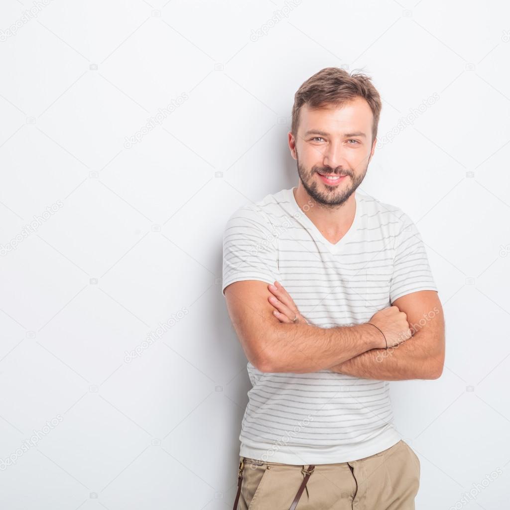 happy young casual man with hands crossed