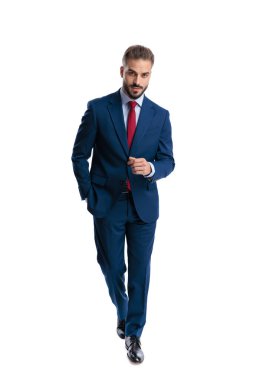 Confident man walking forward with hand in pocket and looking forward isolated on white background
