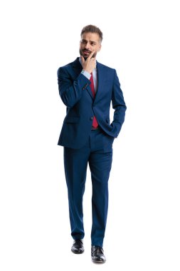 Thoughtful businessman touching chin and thinking while moving on white background