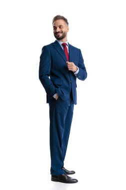 Cheerful businessman holding hand in pocket while looking back over shoulder and smiling isolated on white background