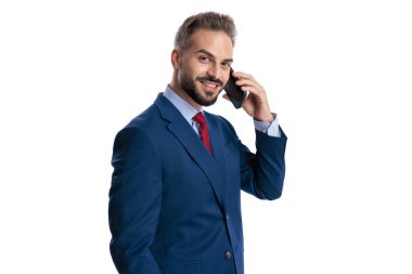 Side view of happy businessman talking on mobile phone and looking to side on white background