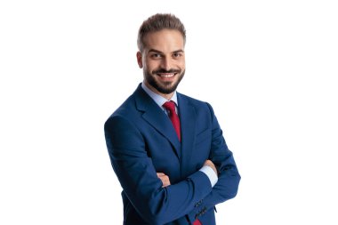 Confident businessman wearing blue suit standing with arms crossed and smiling while looking forward isolated on white background