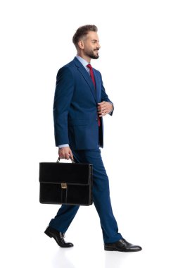 Elinde evrak çantası olan mutlu iş adamının beyaz arka planda tek başına yürümesi.