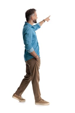 Kot gömlekli gülümseyen adamın yan görünüşü, el ele yürümesi ve beyaz arka planda parmak üstüne parmak gösterilmesi.