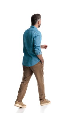 Kot gömlekli sıradan bir adamın arka planda beyaz arka planda el ele yürümesi.