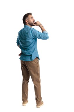 Düşünceli, sıradan bir adamın, beyaz arka plana bakıp düşünürken çenesine dokunması.