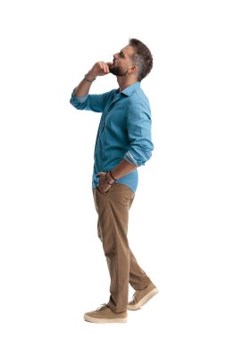 Düşünceli, sıradan bir adamın elleri çenesinde öne doğru çıkarken beyaz arka planda izole edilmiş bir şekilde yukarı bakması.