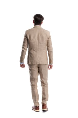 Beyaz arka planda duran bej keten takım elbiseli şık bir adamın arka planı.