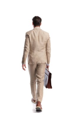 Beyaz arka planda kahverengi deri evrak çantası olan zarif bir adamın yürüyüp gidişinin arka planı.