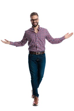 Gözlüklü, kareli gömlekli, kolları açık, beyaz arka planda yalnız yürüyen neşeli bir adam.