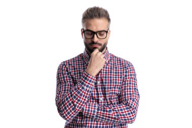 Gözlüklü, çenesine dokunan ve beyaz arka planı kapalı düşünen düşünceli bir adam.