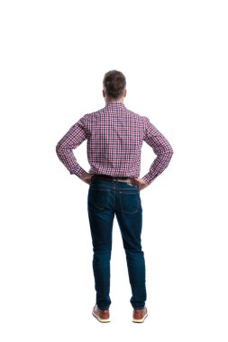 Beyaz arka planda izole edilmiş günlük bir gömlek ve kot pantolon giyerken ellerinin kalçasında duran kendinden emin orta yaşlı bir adamın arka görünüşü.