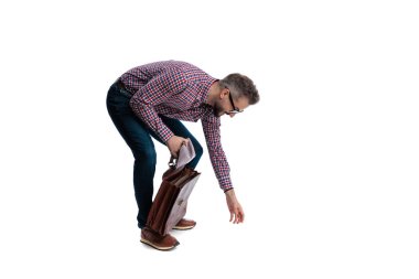 Beyaz arka planda izole edilmiş evrak çantasını tutarken öne eğilip uzanan ekose gömlekli sıradan sakallı adamın yan görüntüsü.