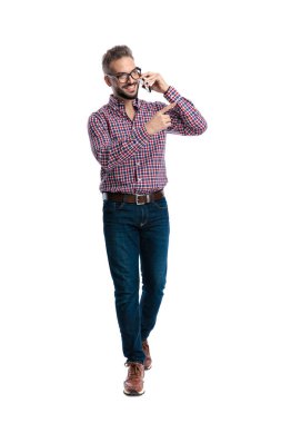 Neşeli, sıradan bir adam cep telefonuyla konuşurken öne çıkıyor ve beyaz arka planda parmağı işaret ediyor.