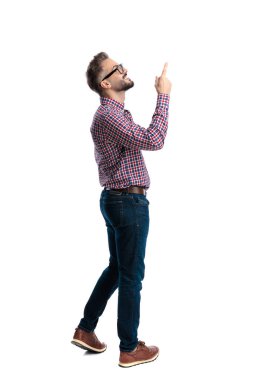 Gözlüklü ve ekose gömlekli neşeli bir adam beyaz arka planda parmaklarını kaldırıp fotokopi odasına bakıyor.