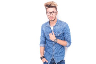 Gözlüklü genç adam onun kot gömlek tutar