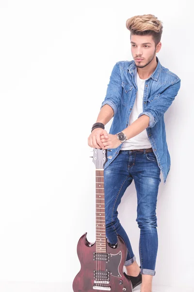 Visão lateral de um jovem guitarrista fazendo uma pausa — Fotografia de Stock