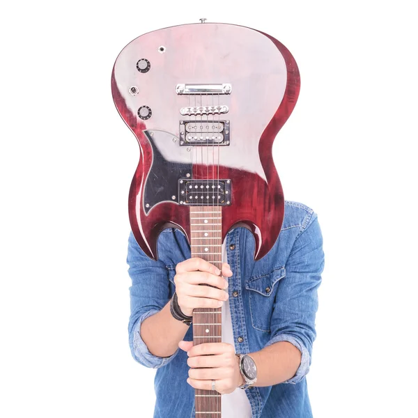 Guitarrista casual segurando guitarra sobre seu rosto — Fotografia de Stock