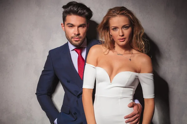 Fashion elegant couple standing embraced in studio — Stock Photo, Image