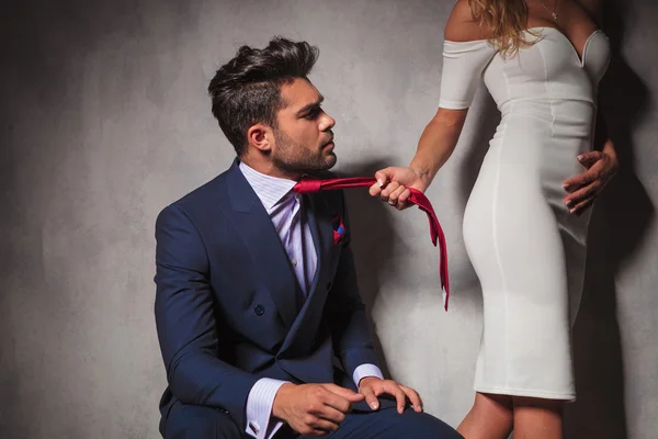 Hombre mirando a su amante mientras ella tira de su corbata — Foto de Stock