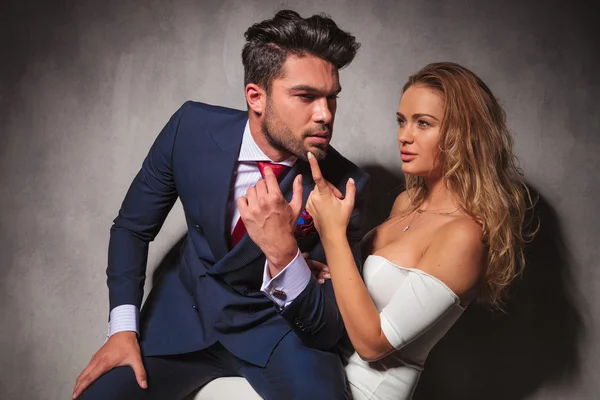 Vista lateral de una pareja caliente y elegante sentada en el estudio — Foto de Stock