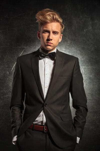 Man posing in studio wearing tuxedo with hands in pockets — Stock Photo, Image