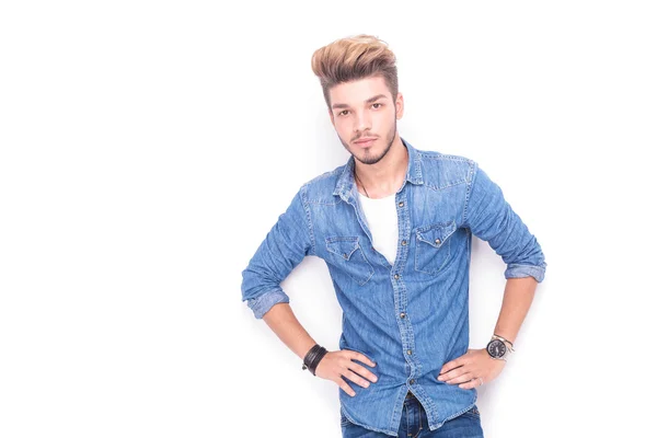 Feliz joven hombre casual con las manos en las caderas sonriendo — Foto de Stock