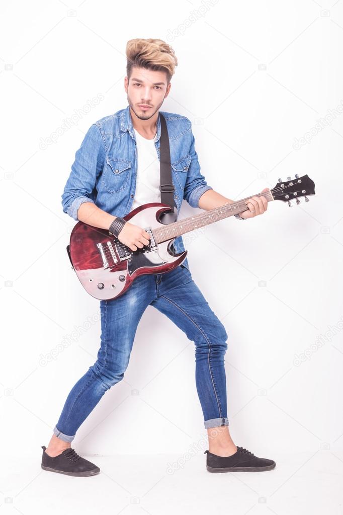 young rocker playing his red electric guitar