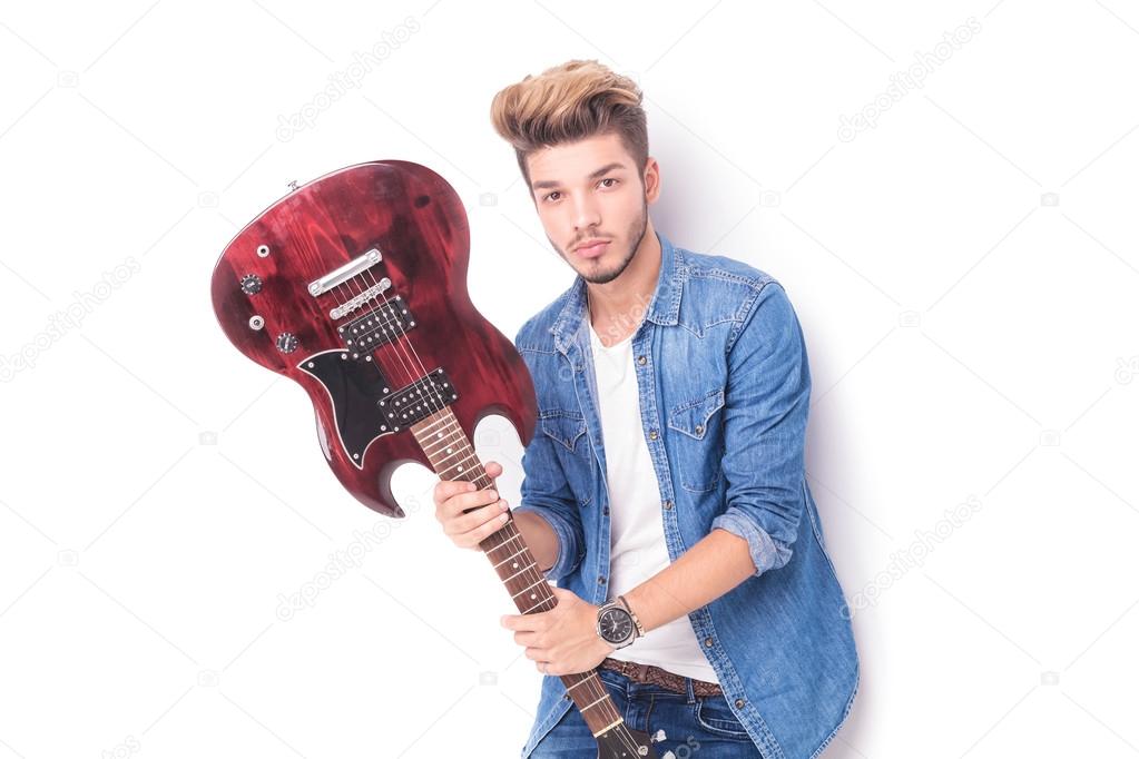 cool casual man holding an electric guitar