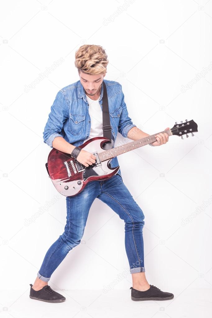 full body picture of a guitarist playing his intrument