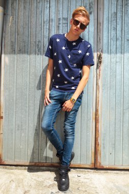 yakışıklı genç metal duvar karşı tam vücut poz