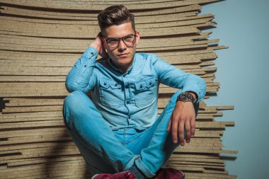 Akıllı adam ahşap stüdyoda oturan gözlüklü