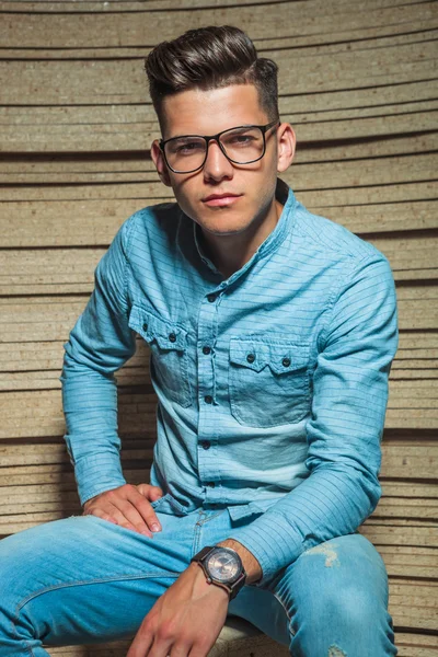 Mann in Jeans mit Brille sitzt und posiert — Stockfoto