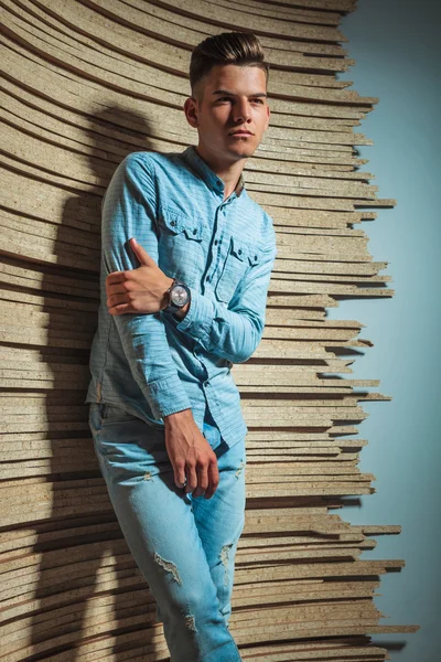 Hombre en denim posando en el estudio mientras se toca el brazo — Foto de Stock