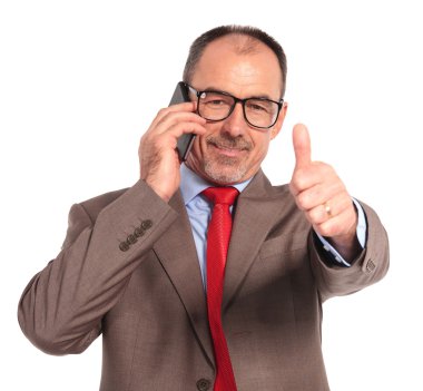 old businessman talking on the phone makes the ok sign