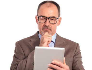 pensive senior businessman reading on his tablet