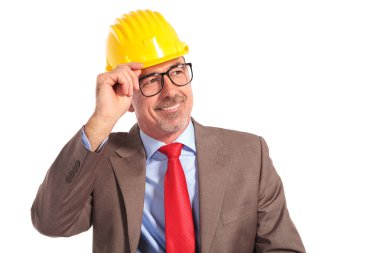smiling old construction engineer holding his helmet as a greeti
