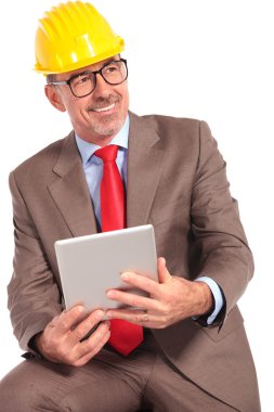 side view of an old construction engineer with tablet pad
