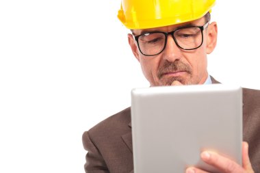 concerned senior construction engineer reading on his tablet