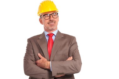 smiling old construction engineer looking up to his side