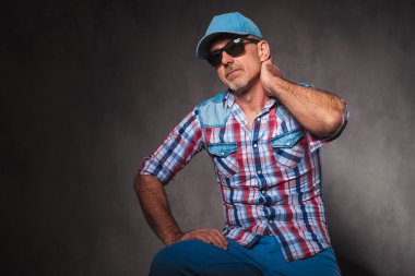 tired casual old man wearing baseball hat and sunglasses