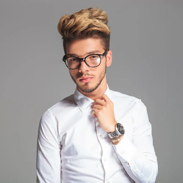 Student bril terwijl poseren en tot vaststelling van zijn shirt — Stockfoto