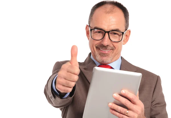 Empresário sênior feliz lendo boas notícias em seu tablet — Fotografia de Stock