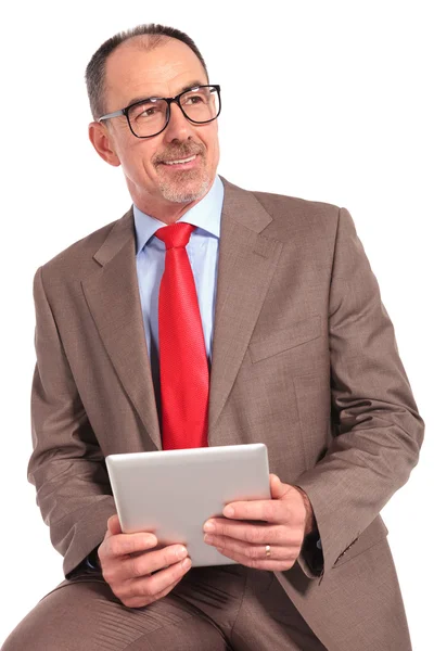 Vista lateral de um empresário sentado e segurando tablet pad — Fotografia de Stock