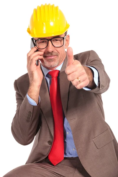Construction engineer talking on the phone and makes  ok sign — Zdjęcie stockowe