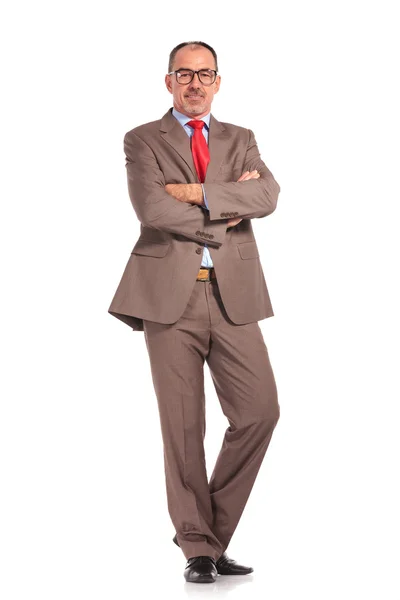 Old happy businessman standing with hands crossed — Stock Photo, Image