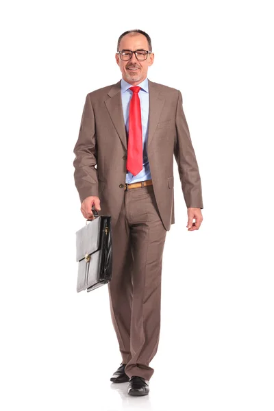 Happy old businessman with briefcase walking forward — Stock Photo, Image