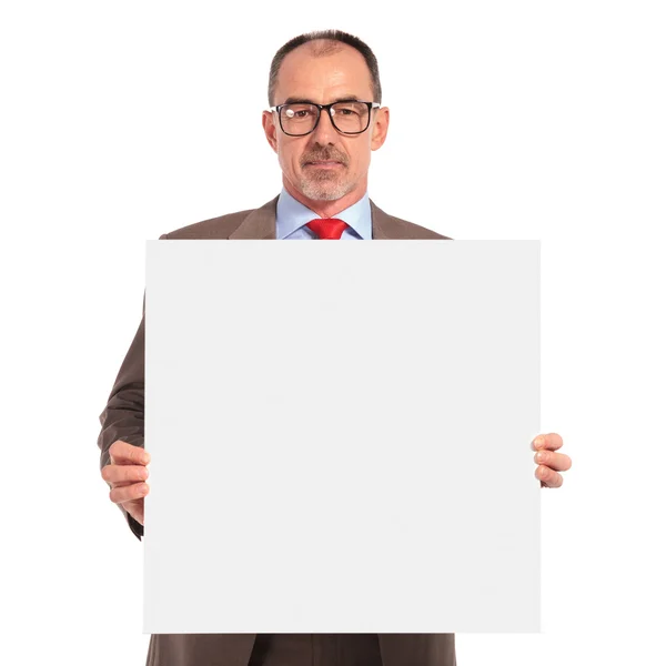 Senior businessman holding a blank board — Stock Photo, Image