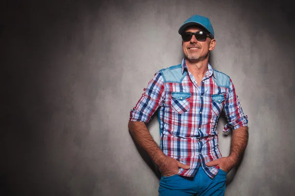 Smiling senior casual man wearing baseball hat looking away — Stock fotografie